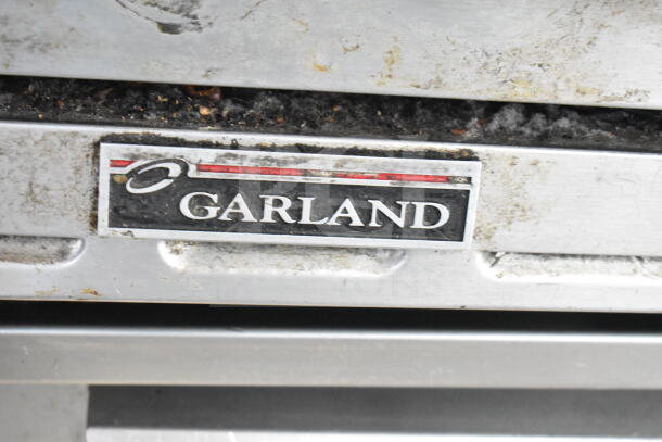 Garland commercial countertop gas-powered 6 burner range, stainless steel, used condition, Garland logo visible.