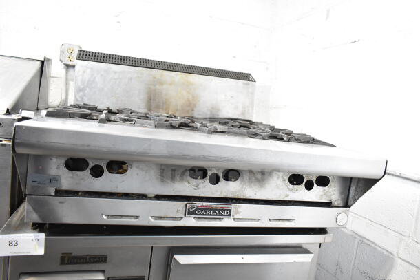 Garland commercial countertop gas-powered 6 burner range, stainless steel, used condition with visible wear, model label intact.