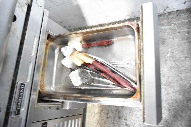 Traulsen Commercial 2 Drawer Chef Base, 115 Volts, 1 Phase, stainless steel drawer open, utensils inside, used condition.