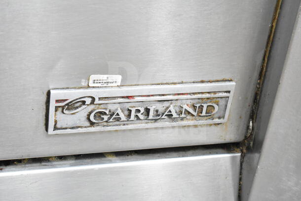 Garland Commercial Gas 6-Burner Range with Convection Oven; stainless steel with visible wear, Garland logo and barcode label.