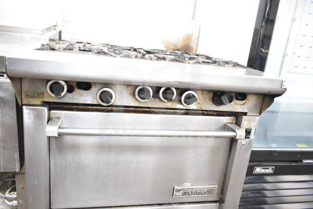 Garland commercial gas-powered 6-burner range with convection oven. Features control knobs and Garland branding. Used condition.