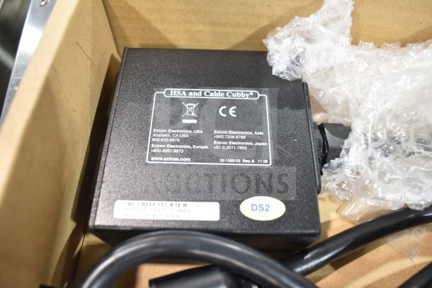 Extron 70-261-01 Cable Cubby AC Power Module, black casing, visible labels with Extron contact info and CE mark.