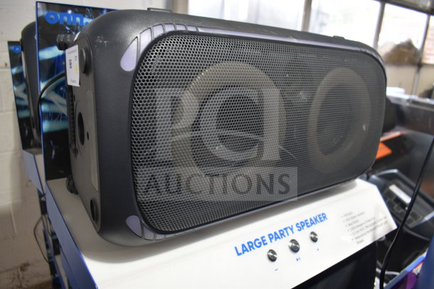 Onn large party speaker on display stand, prominent mesh grille, with visible speaker dials.