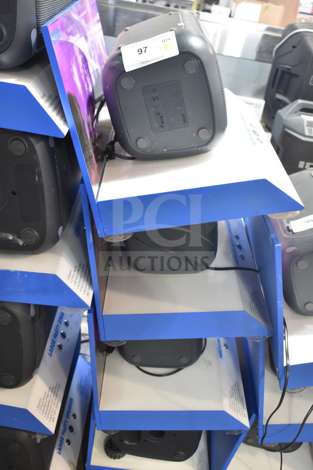 Display with three Onn Medium Party Speakers, USB ports visible. Each on a blue shelf, stickers with quantity tags.
