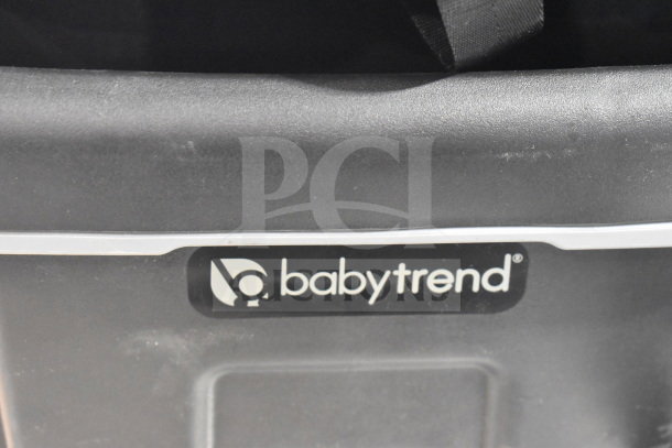 Babytrend Infant Car Seat with Base; close-up of brand logo on black base; minimal wear visible.