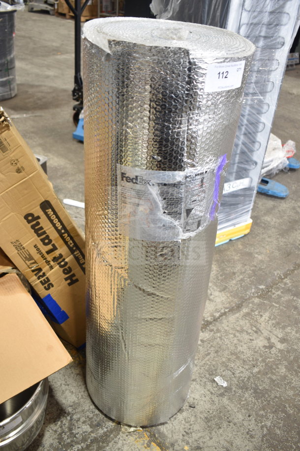 Large roll of bubble wrap packaging, silver-coated, with FedEx label indicating shipping details. In good condition.
