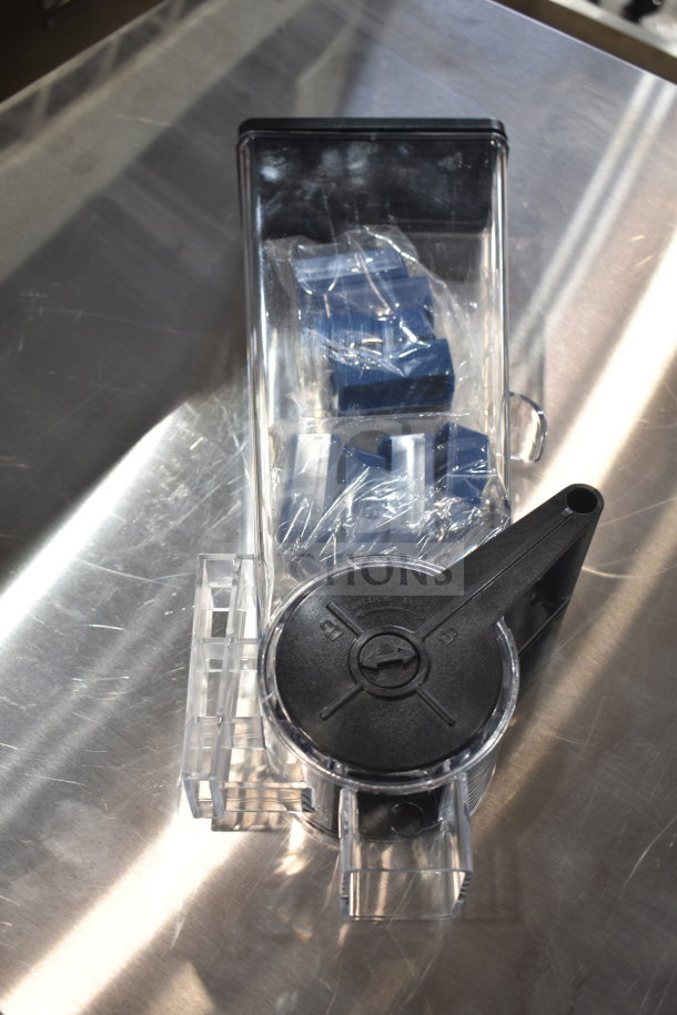 New dry goods dispenser, scratch and dent, intact packaging, black lid with lock/unlock markings, transparent body.