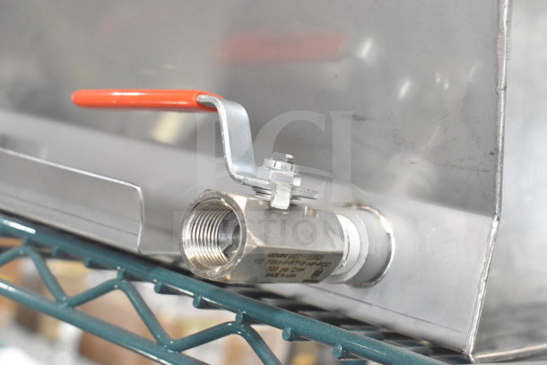 Stainless steel cover with a valve and red handle, labeled for manufacturing detail. Scratch and dent condition. Brand new.