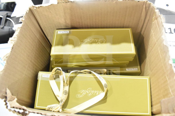 Cardboard box containing brand new cutlery sets, including spoons and forks. Boxes labeled "Salad Forks" and "Dinner Forks."