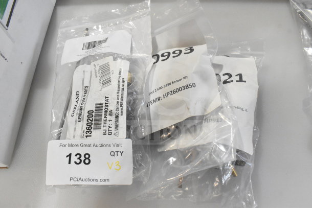 Three brand new scratch-and-dent thermostats, including Crown Steam 9126-1 and Garland/US Range 1360200, in labeled packaging.