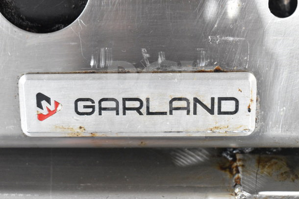 Garland Commercial Gas Flat Top Griddle, stainless steel, slight wear, company logo displayed prominently. Ideal for foodservice.