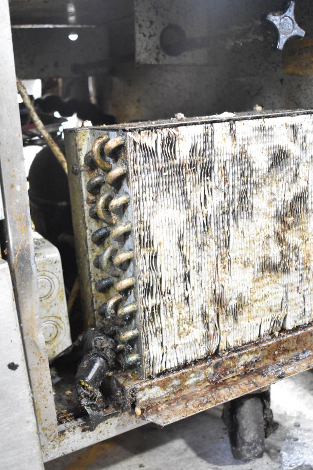 Delfield commercial 4-drawer chef base on casters, 115 volts, 1 phase. Visible wear, rusted components shown.