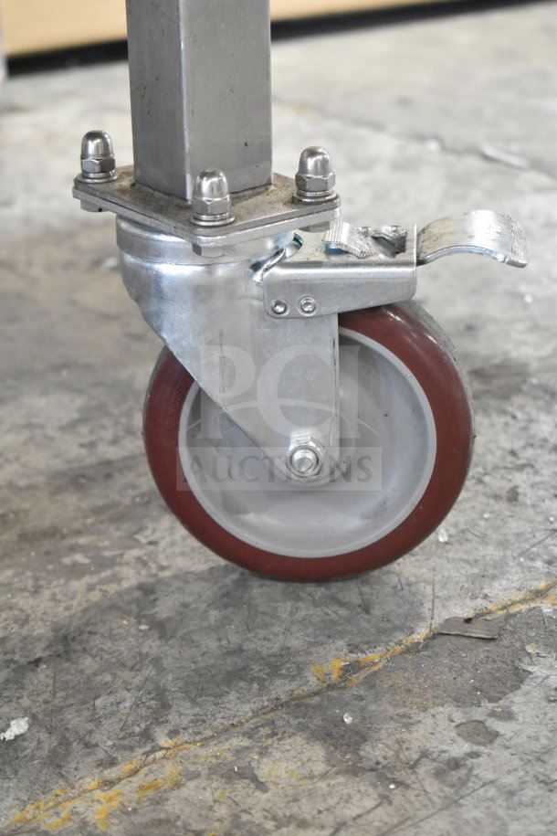 Commercial caster wheel on equipment stand, supporting Turbochef HhC2020 oven. Durable metal frame, smooth rubber wheel.