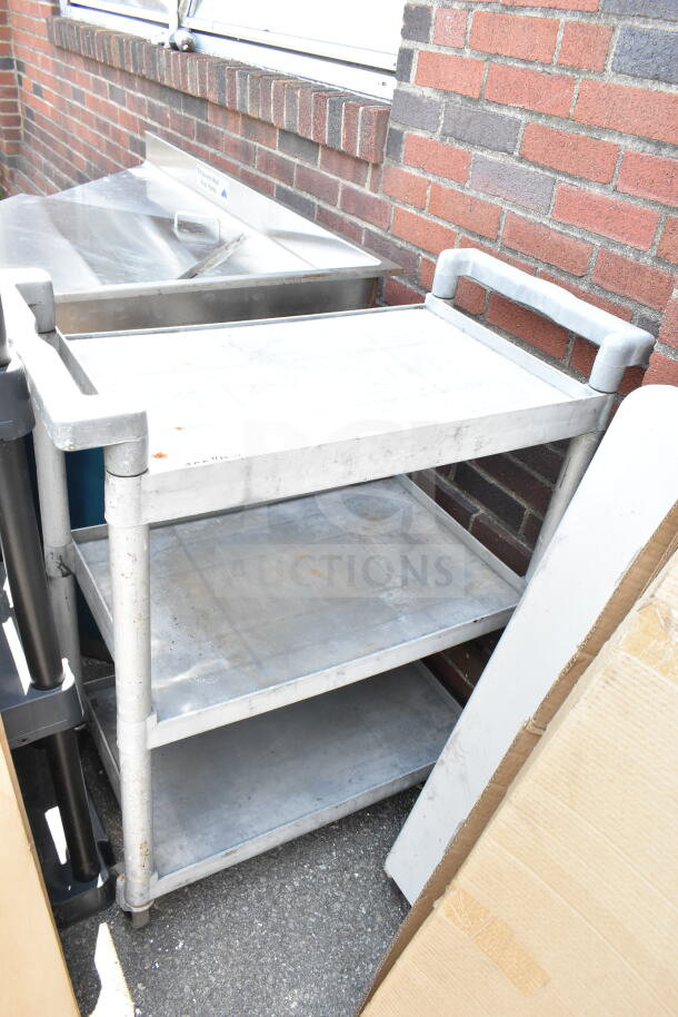 Gray poly 3-tier cart with commercial casters, used condition, sturdy construction, ideal for industrial settings.