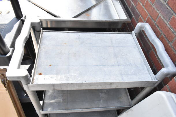 Gray poly 3-tier cart on commercial casters, with sturdy side handles. Minor surface wear, ideal for heavy-duty use.