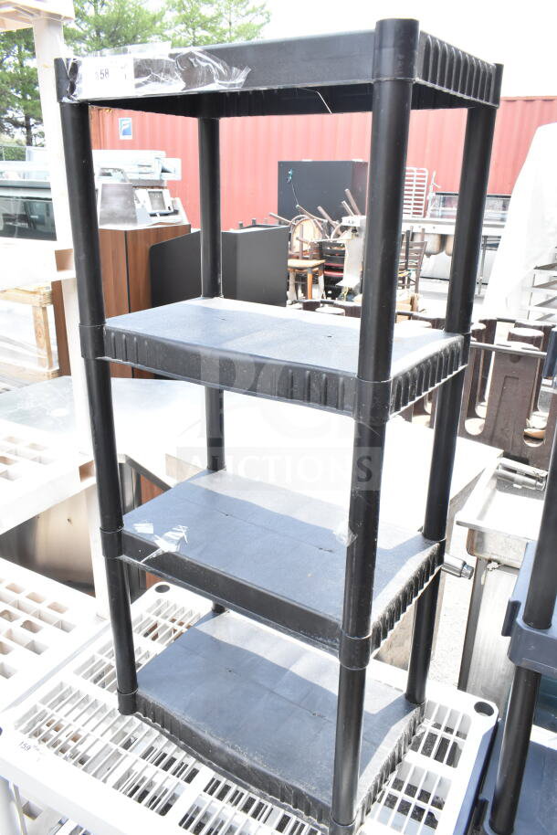 Black poly 4-tier shelving unit, durable plastic, sturdy structure, good condition, ideal for garage or storage use.