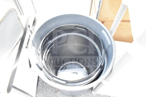 Two black plastic trash cans, nested, showing signs of wear, ideal for waste management.
