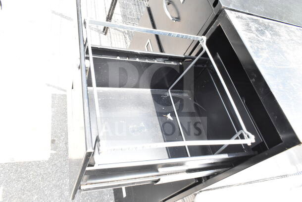 Two black 4-drawer filing cabinets, metal construction, minor surface wear, open drawer showing interior structure.