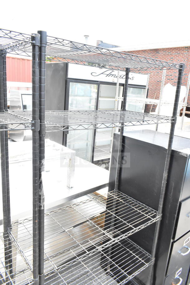 Black 5-tier wire shelving unit, metallic finish, sturdy construction, must be dismantled by buyer, freight charges apply.
