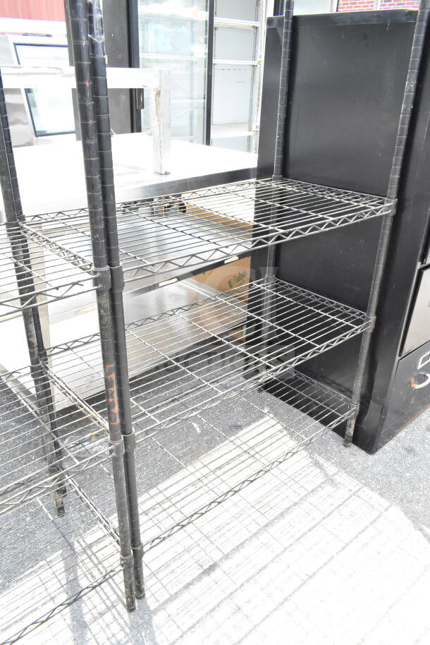 Black 5-tier wire shelving unit, sturdy construction, minor wear. Buyer must dismantle for shipping; consider freight costs.