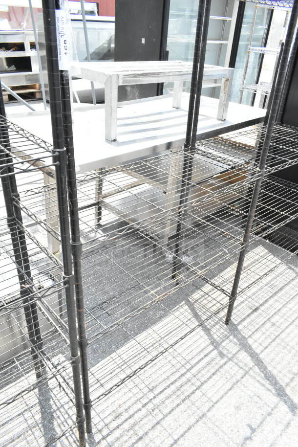 Black 5 tier wire shelving unit in good condition, suitable for storage. Buyer must dismantle; consider freight charges.