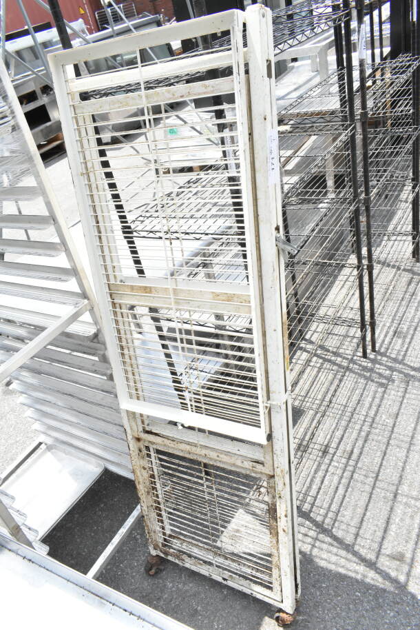Industrial metal rack with wire shelves and white frame, showing signs of rust. Suitable for storage use.
