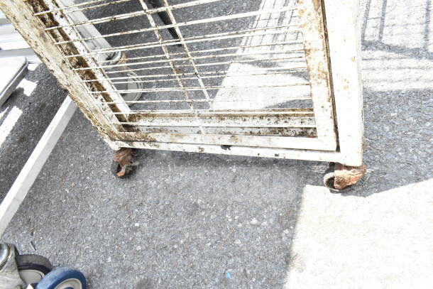 Rusty metal rack with caster wheels, showing significant wear and corrosion, suitable for industrial or storage use.