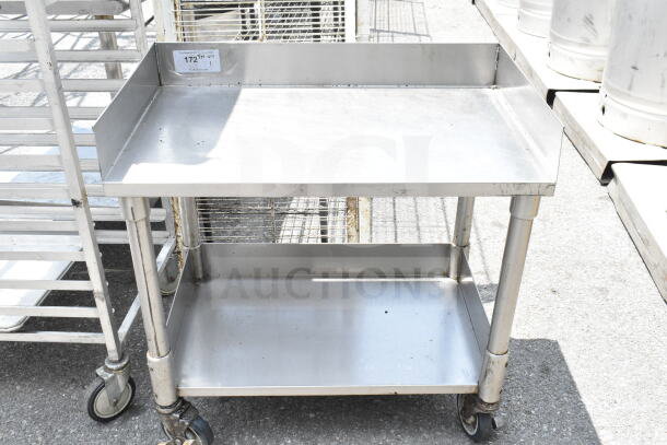Commercial equipment stand with under shelf and casters. Made of stainless steel, good condition, tag indicates model 172N.