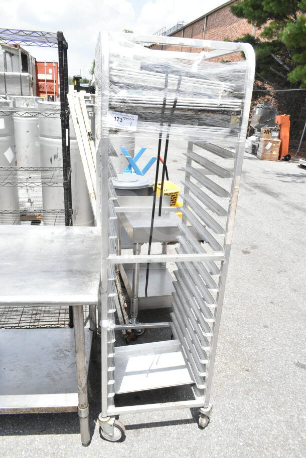 Commercial pan transport rack with multiple shelves on durable casters, wrapped for protection. Label shows quantity and code.