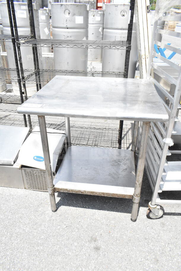 Commercial metal table with under shelf, used condition. Ideal for industrial kitchens, durable surface, and sturdy legs.