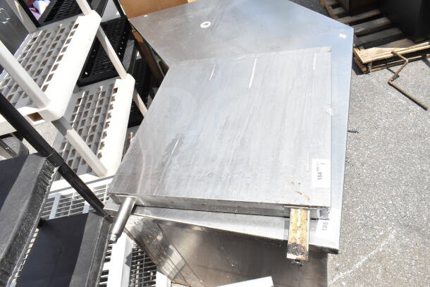 Metal panel with a stainless steel finish, showing minor wear. Visible labels have item numbers 184 and 195.
