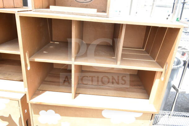 Two wooden cabinets with multiple shelves, simple design. Light wood finish, showing slight wear.