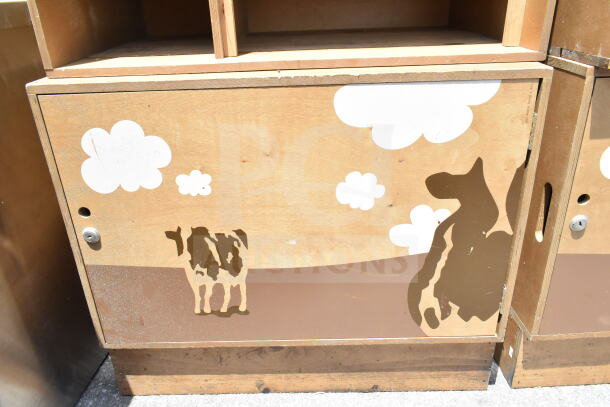 Two wooden cabinets with cow and cloud designs, keyhole feature. Visible wear. Auction includes both cabinets.