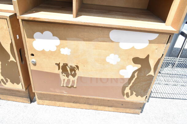 Two wooden cabinets with playful farm animal and cloud designs, in fair condition. Ideal for storage and decorative use.