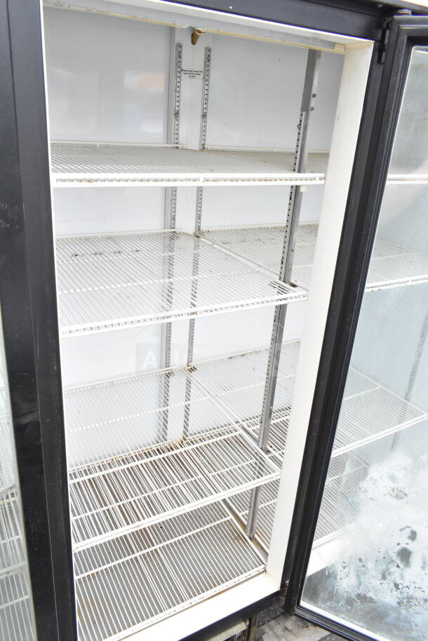 Beverage Air MT72 commercial cooler, 3 glass doors, metal shelves, 115V, 1 phase. Used condition with visible wear.