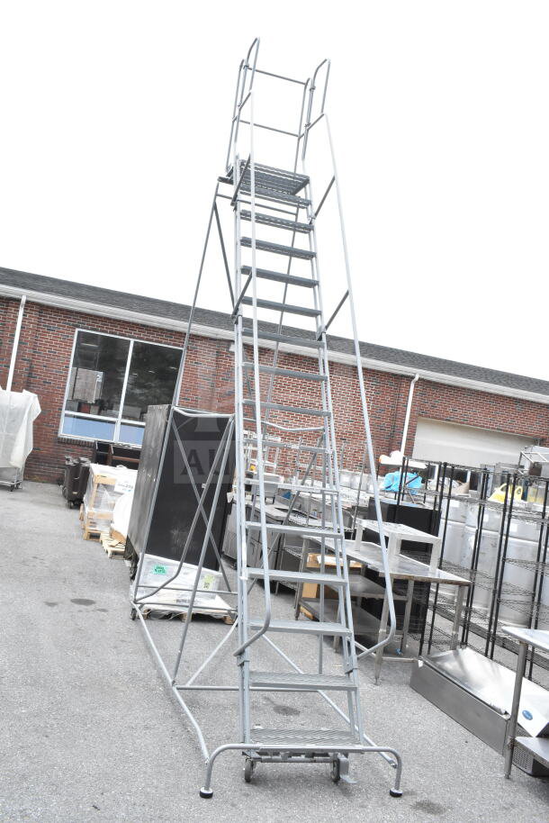 Gray portable ladder steps with safety rails, metal construction, good condition, on wheels for easy mobility.