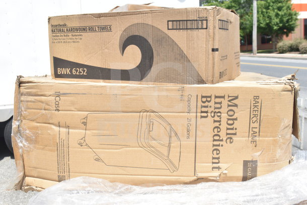 Cardboard boxes of Boardwalk natural hardwound roll towels and Baker's Lane mobile ingredient bin, 21-gallon capacity, visible.