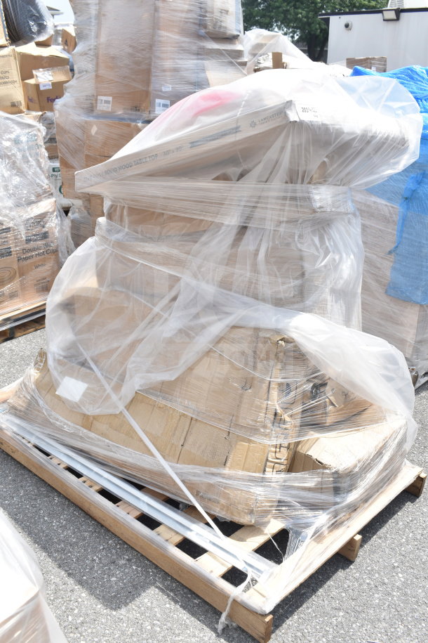 9 new scratch and dent items, including a solid wood table top and trash can lids, wrapped on a pallet.