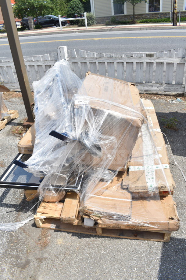 Plastic-wrapped pallet with 12 new scratch and dent items, including an ice bin and rack shelf. Cardboard boxes visible.