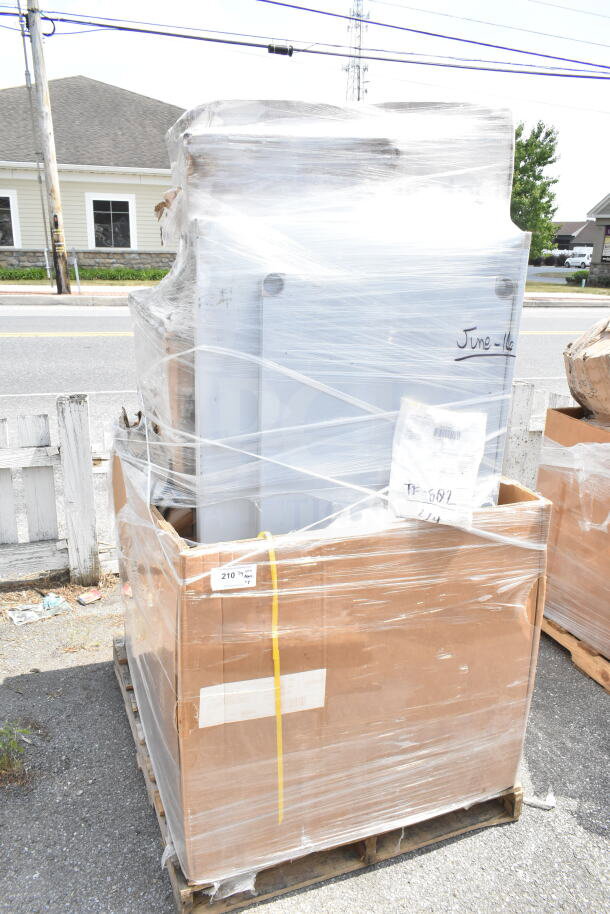 Stack of 8 brand-new but scratch and dent items, including a work table and seafood boiler cart, wrapped in plastic on a pallet. Labels read "June-16" and "210."