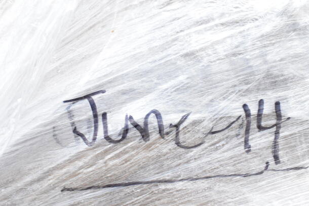 Close-up of plastic-wrapped items with "June-14" written on the surface; auction lot of 8 brand new items, including a compressor and containers.