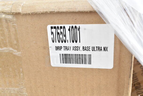 Cardboard box with label reading "57659.1001 DRIP TRAY ASSY, BASE ULTRA NX," part of 34 brand new scratch and dent items.