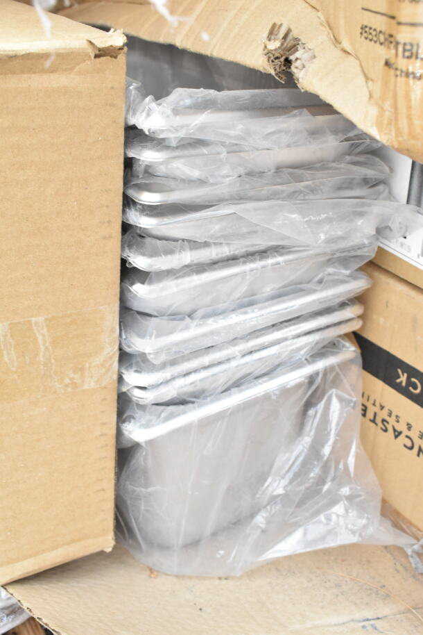 Stack of trays in plastic wrap, new condition in damaged cardboard box. Part of a 34-piece scratch and dent auction lot.