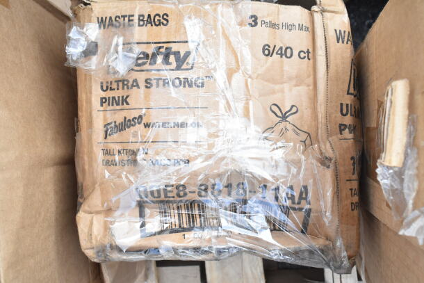 Cardboard boxes labeled "Hefty Ultra Strong Pink" waste bags, wrapped in clear plastic, showing packaging details.