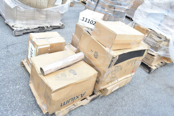 Boxes of brand new scratch and dent items on a pallet, including pizza pans. Labels and shipping markings visible.