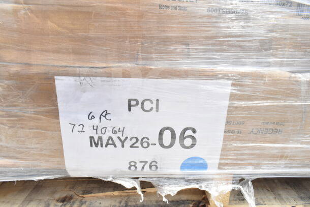 Pallet wrapped in plastic with a label reading "PCI MAY26-06" and handwritten numbers, indicating a lot of six scratch and dent items, including a work table and sink.