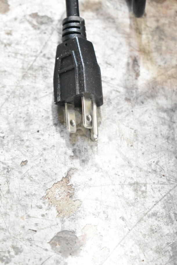 Black power plug for Conti Valerio Zenith Touch commercial grinder, 110-120V, shown against a scratched surface.