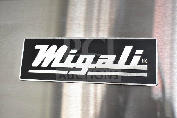 Brand logo of Migali on the stainless steel surface of the 2019 C-3F Commercial 3-Door Reach-In Freezer.