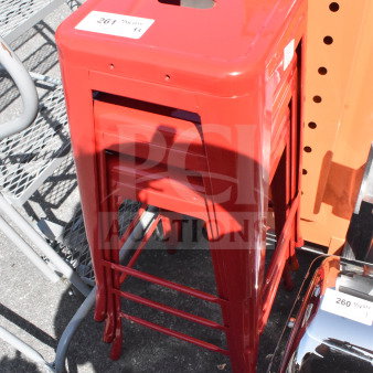 Three new scratch and dent red Tolix-style bar stools, stacked, with tags indicating lot number 261.