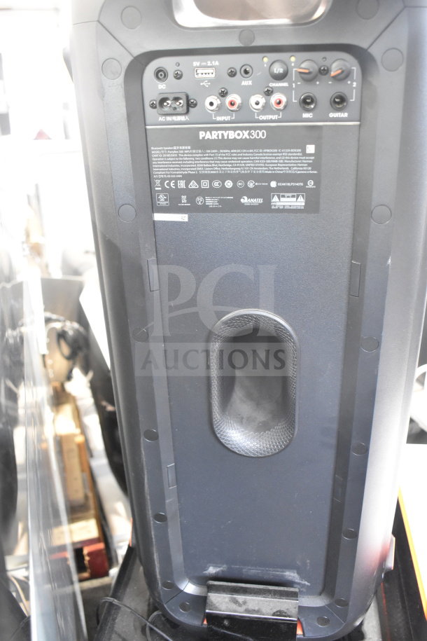 JBL Partybox 300 speaker on store display, showcasing rear panel inputs and labels, in excellent condition.